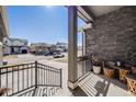 Inviting front porch with a stylish railing, stone accents, and a welcoming neighborhood view at 671 Green Mountain Dr, Erie, CO 80516