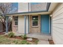 Inviting front porch with a colorful door, brick accents, and manicured landscaping at 8603 Barberry Pl, Parker, CO 80134