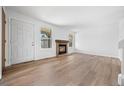 Bright living room with new flooring, a cozy brick fireplace, and lots of natural light at 8603 Barberry Pl, Parker, CO 80134