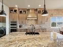 Spacious kitchen featuring granite countertops, brick backsplash, and stainless steel appliances, ideal for cooking at 23713 E Eads Dr, Aurora, CO 80016
