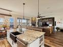 Open-concept kitchen with an island, dining area with outdoor access, flowing into a cozy living space at 23713 E Eads Dr, Aurora, CO 80016