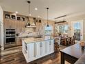 Gorgeous kitchen with brick backsplash, large island, stainless appliances, and adjacent dining area with outdoor views at 23713 E Eads Dr, Aurora, CO 80016