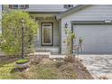 Close up of front door with sidelight, surrounded by landscaping; two-car garage on the right at 5316 S Rome St, Aurora, CO 80015
