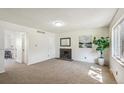 Bright living room featuring neutral carpet, fireplace, and fresh white walls at 3685 W Union Ave, Denver, CO 80236