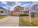 Charming two-story home with a well-manicured front lawn and attached two-car garage at 18736 E Powers Pl, Aurora, CO 80015