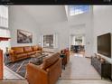 Modern living room with high ceilings, leather sofas, and ample natural light at 18736 E Powers Pl, Aurora, CO 80015