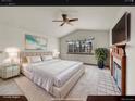Relaxing bedroom features plush king bed, fireplace, and backyard view at 18736 E Powers Pl, Aurora, CO 80015