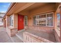 Inviting front porch with brick accents and a bright red front door at 18736 E Powers Pl, Aurora, CO 80015