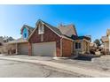 Spacious two-car garage with brick and siding exterior, showcasing ample parking and curb appeal at 2135 S Troy Way, Aurora, CO 80014