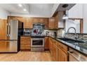 Well-lit kitchen with stainless steel appliances, granite countertops, and stylish tile backsplash at 2135 S Troy Way, Aurora, CO 80014