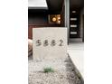 This features a modern front door with glass inserts and a contrasting brick and siding exterior at 5882 W Chestnut Ave, Littleton, CO 80128