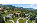 Expansive aerial view showcasing the property's landscaping, neighborhood, and mountain views in the background at 69 N Ranch Rd, Littleton, CO 80127