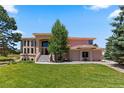 Beautiful two-story home showcasing a well-manicured lawn, landscaped garden, and classic architectural style at 69 N Ranch Rd, Littleton, CO 80127