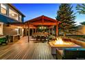 Inviting outdoor patio with built-in grill, dining area, fire pit and cozy seating at 16267 W 59Th Pl, Golden, CO 80403