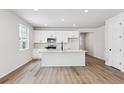 Bright kitchen features white cabinets, an island, and modern appliances at 803 Goodrich Peak St, Erie, CO 80516
