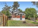 Charming backyard featuring a well-maintained lawn, a fire pit, and a quaint brick home exterior at 3655 Zenobia St, Denver, CO 80212