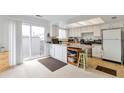 Open kitchen design boasts ample counter space, white cabinetry, and access to a sliding glass door to backyard at 9207 E Mansfield Ave, Denver, CO 80237