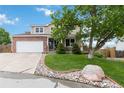 Attractive exterior view of a two-story home boasting a manicured lawn and attached garage at 10870 Crestone Needles Dr, Parker, CO 80138