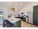 Updated kitchen features stainless steel appliances, white countertops, and bar seating at 2923 W Bryant Cir, Littleton, CO 80120