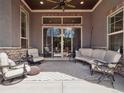 Covered patio with comfortable seating, ceiling fan, and large sliding glass doors to the backyard at 6970 E Lake Dr, Centennial, CO 80111