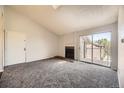 Living room with fireplace, carpet flooring, balcony access, and natural light at 4899 S Dudley St # 20G, Littleton, CO 80123