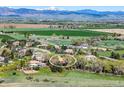 Wide-angle aerial view of home in rural setting with mountain views and open fields at 7760 Crestview Ln, Niwot, CO 80504