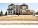 Two-story home with stone accents, covered porch, well-maintained lawn, and a neutral color scheme at 23270 E Rockinghorse Pkwy, Aurora, CO 80016