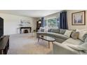 Bright living room featuring a large sectional sofa, neutral carpet, and a large window at 590 S Troy St, Aurora, CO 80012