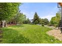 Lush backyard featuring a well-maintained lawn, mature trees, and recreational space with room to play at 24702 E Ontario Dr, Aurora, CO 80016