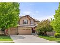 Charming two-story home featuring a well-manicured front lawn, a three-car garage and a welcoming entrance at 24702 E Ontario Dr, Aurora, CO 80016