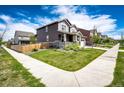 Beautifully landscaped front yard of a two-story home featuring a green lawn, a sidewalk, and a wooden fence at 960 S De Gaulle Ct, Aurora, CO 80018
