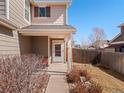 Covered front porch with neutral siding, white columns, and tidy landscaping at 896 Willow Dr, Brighton, CO 80603