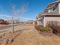 Well-maintained front yard with a tree and view of a quiet residential street at 896 Willow Dr, Brighton, CO 80603