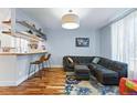 Comfortable living room area featuring bar seating, hardwood floors, and modern lighting at 3170 W 29Th Ave, Denver, CO 80211