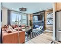 Inviting living room features a cozy sectional sofa, stylish fireplace, and large window at 2475 W 69Th Pl, Denver, CO 80221