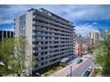 Exterior shot of a modern high rise apartment building with parking and landscaping at 909 N Logan St # 6K, Denver, CO 80203