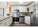 Updated kitchen with white cabinetry, stainless steel appliances, and a decorative tile backsplash at 909 N Logan St # 6K, Denver, CO 80203