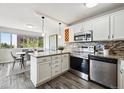 Modern kitchen with stainless steel appliances, granite countertops, and an adjacent dining area at 909 N Logan St # 6K, Denver, CO 80203