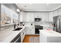 Bright kitchen with stainless steel appliances, white cabinets, and stylish backsplash at 10015 Apollo Bay Way, Highlands Ranch, CO 80130