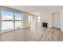 Bright living room featuring wood floors, a fireplace, and sliding glass doors to the exterior at 14131 Bunny Hop Ln, Parker, CO 80134