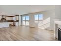 Open living space with fireplace, wood floors, open kitchen with island and sliding glass doors at 14131 Bunny Hop Ln, Parker, CO 80134