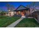 Charming brick home with a covered front porch, dark trim, and beautifully manicured lawn at 2930 W 34Th Ave, Denver, CO 80211