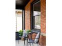 Close-up of the front porch, highlighting the seating area with natural light and brick details at 2930 W 34Th Ave, Denver, CO 80211