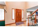 Bright and airy foyer with hardwood floors and a wooden front door at 17085 E Dorado Cir, Centennial, CO 80015