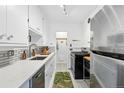 Well-maintained kitchen with white cabinets, quartz countertops, stainless steel appliances, and subway tile backsplash at 1175 N Emerson St # 103, Denver, CO 80218
