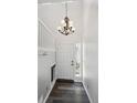 Bright foyer with a stylish chandelier, hardwood floors, and a convenient coat rack at 5193 E 119Th Way, Thornton, CO 80233