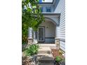 Inviting front porch with stone accents and a well-landscaped garden, leading to the front door at 5193 E 119Th Way, Thornton, CO 80233