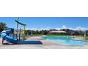 Resort-style community pool featuring a colorful waterslide and plenty of lounge seating at 4592 Windmill Dr, Brighton, CO 80601