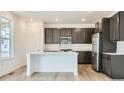 Beautiful kitchen featuring dark cabinets, stainless steel appliances, and a central island with white countertops at 4592 Windmill Dr, Brighton, CO 80601