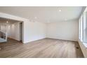 Bright, open-concept living room with light wood floors and ample natural light streaming through the windows at 4592 Windmill Dr, Brighton, CO 80601